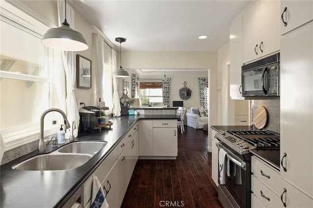 kitchen featuring pendant lighting, sink, dark hardwood / wood-style floors, stainless steel gas range oven, and white cabinets