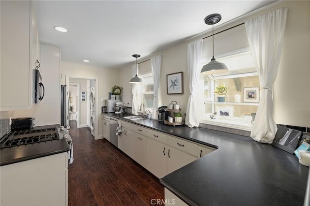 kitchen featuring white cabinetry, sink, decorative light fixtures, and stainless steel appliances