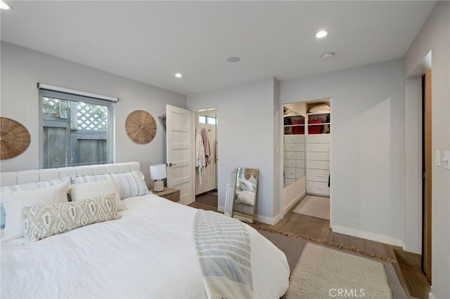 bedroom featuring hardwood / wood-style flooring, a spacious closet, and a closet