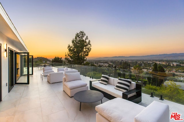 patio terrace at dusk featuring outdoor lounge area and a mountain view