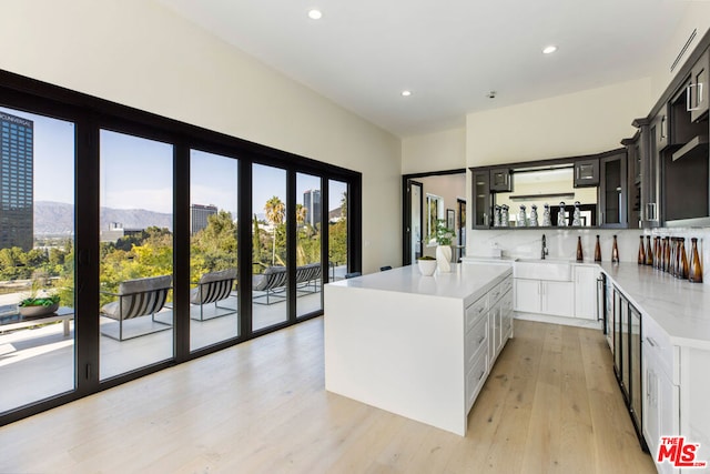 kitchen featuring sink, light hardwood / wood-style flooring, white cabinets, a kitchen island, and a mountain view