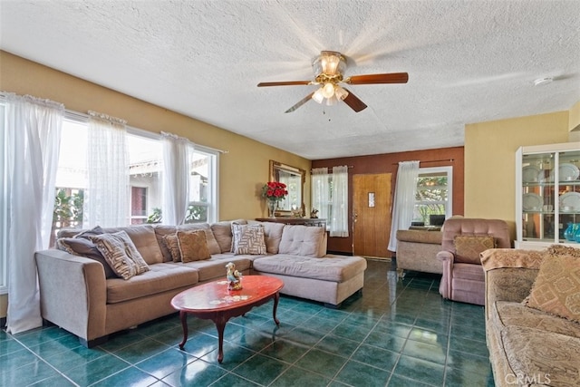 living room with ceiling fan and a textured ceiling