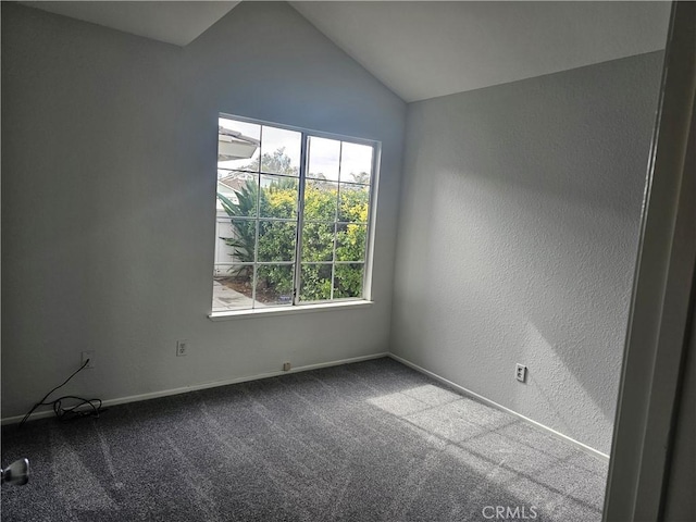 carpeted spare room with lofted ceiling