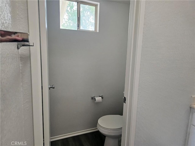 bathroom featuring wood-type flooring and toilet