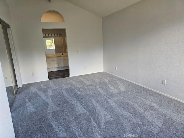 spare room featuring beamed ceiling, sink, high vaulted ceiling, and dark colored carpet