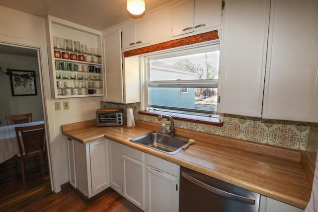 kitchen with dark hardwood / wood-style floors, white cabinetry, sink, backsplash, and stainless steel dishwasher