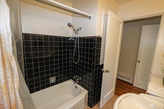 bathroom with a baseboard heating unit and shower / bath combo with shower curtain