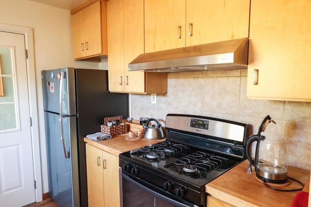 kitchen featuring tasteful backsplash, black range with gas stovetop, stainless steel fridge, and extractor fan