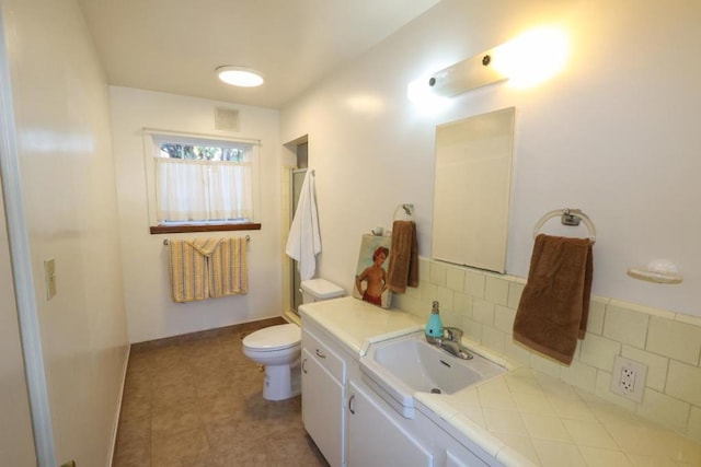 bathroom featuring tasteful backsplash, vanity, and toilet