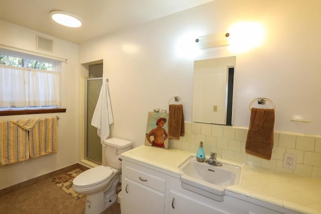 bathroom featuring tasteful backsplash, vanity, tile patterned floors, and toilet