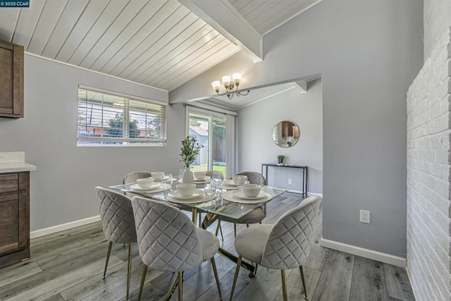 dining space featuring a chandelier, light hardwood / wood-style floors, lofted ceiling with beams, and wooden ceiling