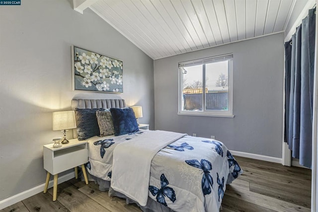 bedroom featuring lofted ceiling with beams and hardwood / wood-style flooring