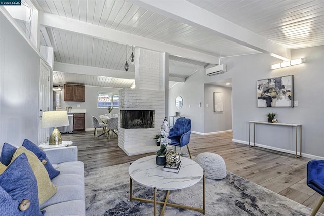 living room featuring wood-type flooring, an AC wall unit, vaulted ceiling with beams, and a brick fireplace