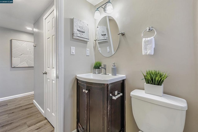 bathroom with vanity, toilet, and hardwood / wood-style floors