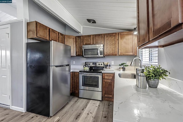 kitchen with light hardwood / wood-style flooring, sink, vaulted ceiling, and stainless steel appliances