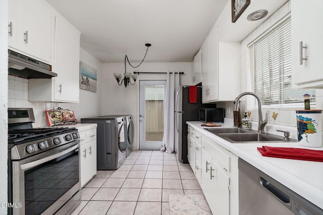 kitchen featuring under cabinet range hood, stainless steel appliances, a sink, light countertops, and independent washer and dryer