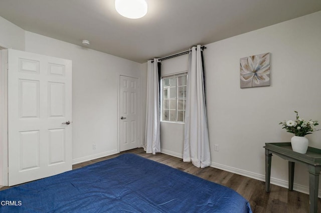 unfurnished bedroom featuring wood finished floors and baseboards