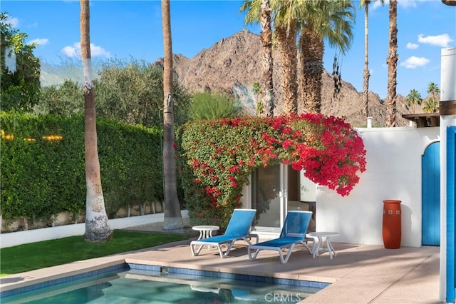 back of property with a mountain view and a patio