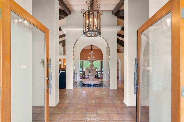 hallway with beam ceiling, high vaulted ceiling, wooden ceiling, and a chandelier