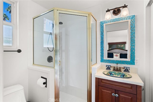 bathroom featuring vanity, a shower with door, and toilet