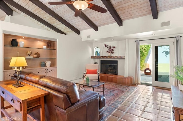 living room with wood ceiling, a fireplace, built in shelves, and beamed ceiling