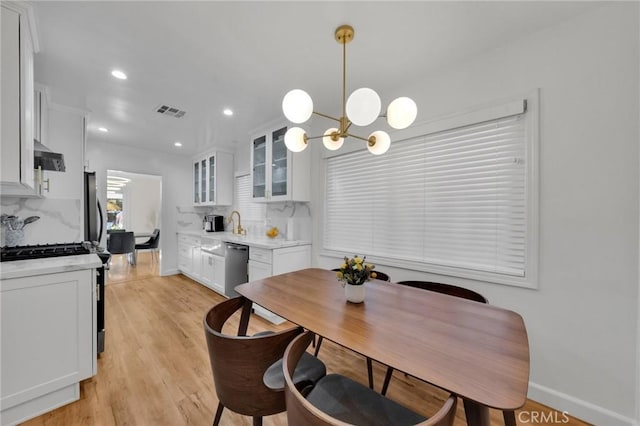 dining area featuring a chandelier and light wood-type flooring