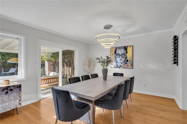 dining room with a notable chandelier, crown molding, and light hardwood / wood-style floors