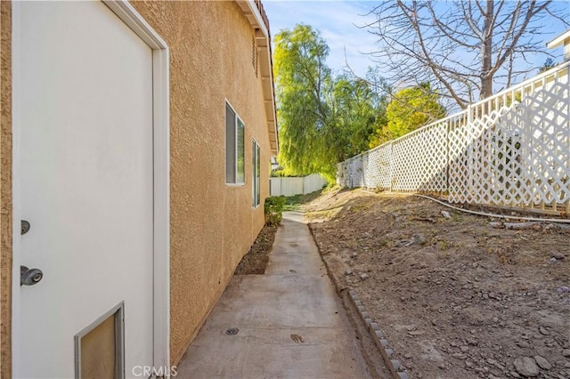 view of property exterior featuring fence and stucco siding