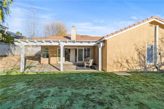 back of house with stucco siding, a patio area, a yard, and a pergola