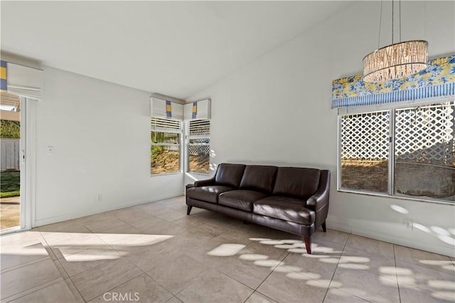 sitting room with lofted ceiling, a notable chandelier, and light tile patterned floors