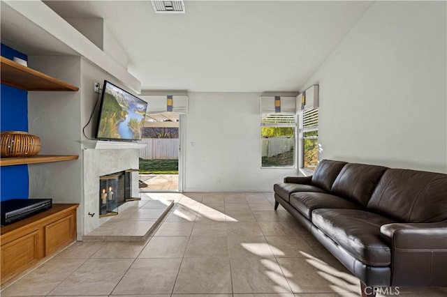 living room featuring light tile patterned floors, a fireplace, and visible vents