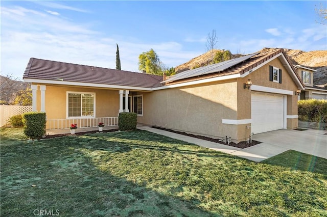 ranch-style home with a garage, roof mounted solar panels, driveway, and stucco siding