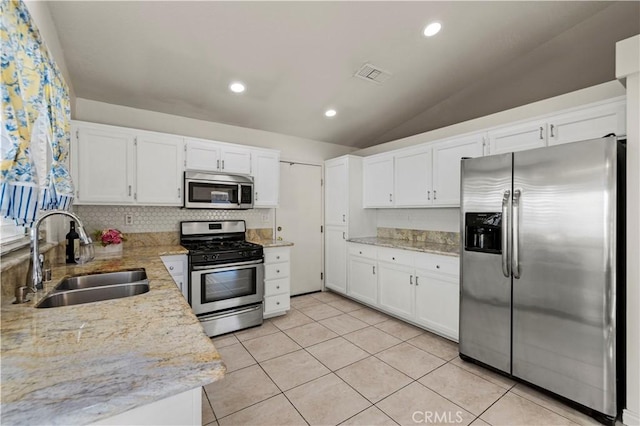 kitchen with appliances with stainless steel finishes, white cabinetry, a sink, and visible vents