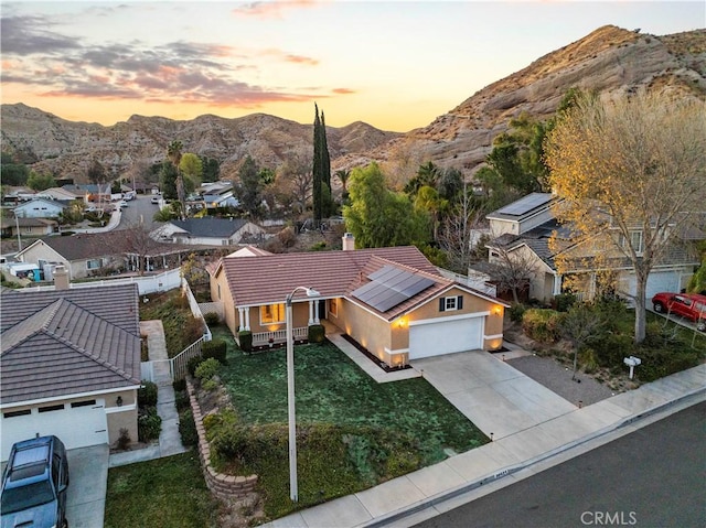 aerial view at dusk featuring a residential view and a mountain view