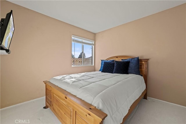 bedroom featuring light carpet and baseboards