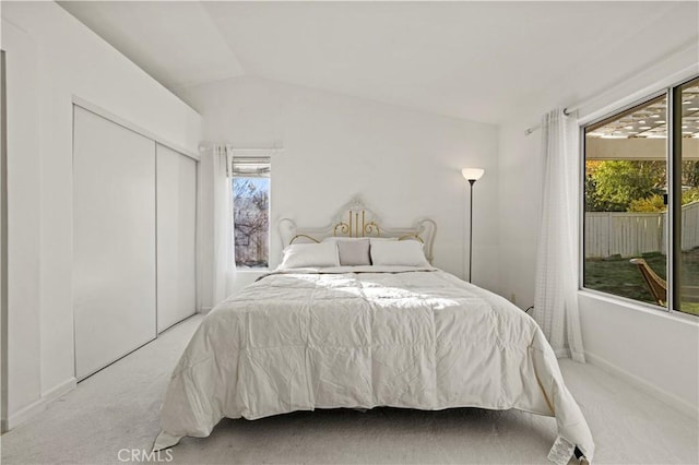 bedroom featuring light colored carpet, multiple windows, and vaulted ceiling