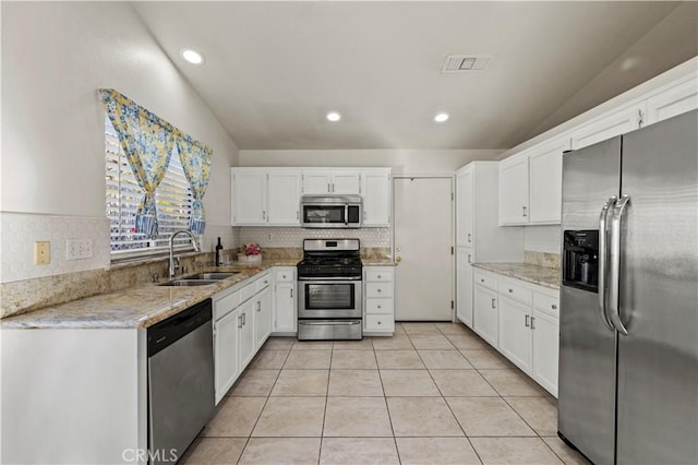 kitchen featuring stainless steel appliances, a sink, visible vents, and white cabinets