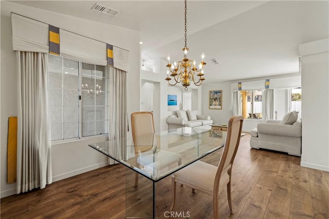 dining room featuring a chandelier, visible vents, baseboards, and hardwood / wood-style flooring