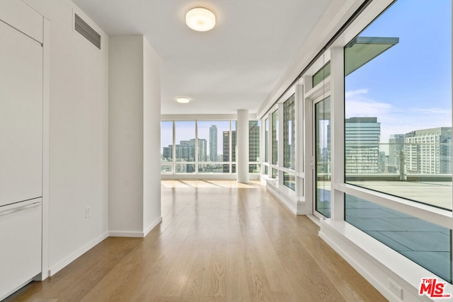 hall with plenty of natural light and light wood-type flooring