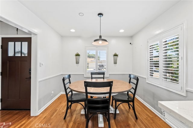 dining space with wood-type flooring