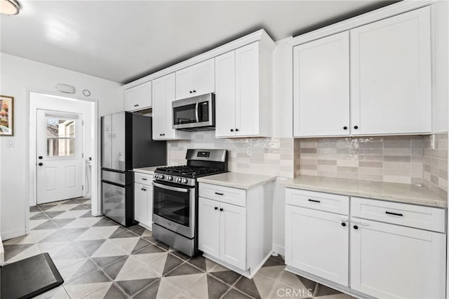 kitchen with white cabinetry, backsplash, and stainless steel appliances