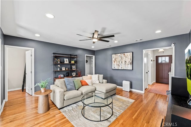 living room with light hardwood / wood-style flooring and ceiling fan