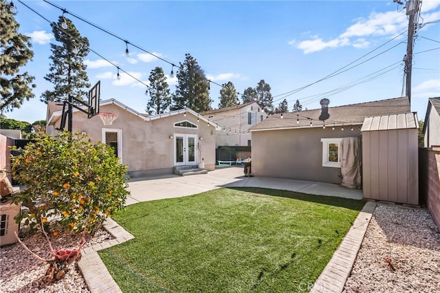 rear view of property with a yard, a patio area, and french doors