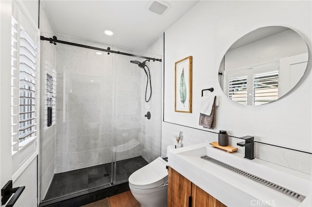 bathroom featuring toilet, a shower with shower door, wood-type flooring, tile walls, and vanity