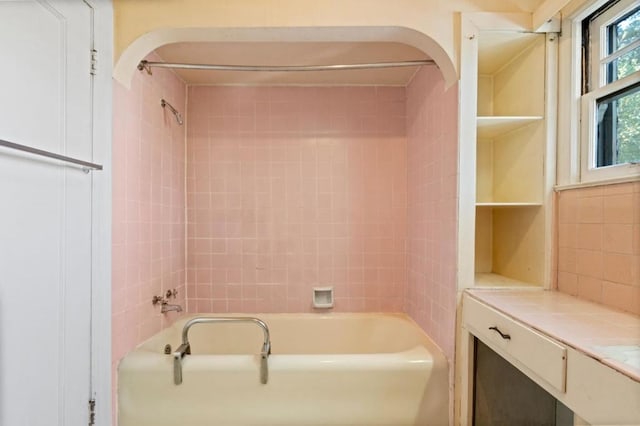 bathroom featuring tiled shower / bath and vanity