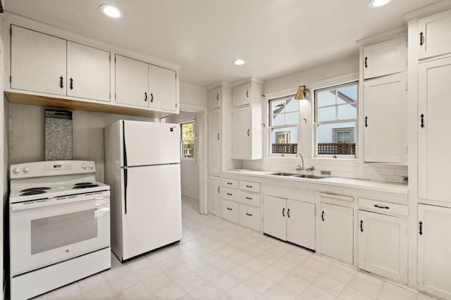 kitchen with white cabinetry, sink, white appliances, and a healthy amount of sunlight