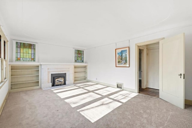 unfurnished living room featuring a healthy amount of sunlight and carpet