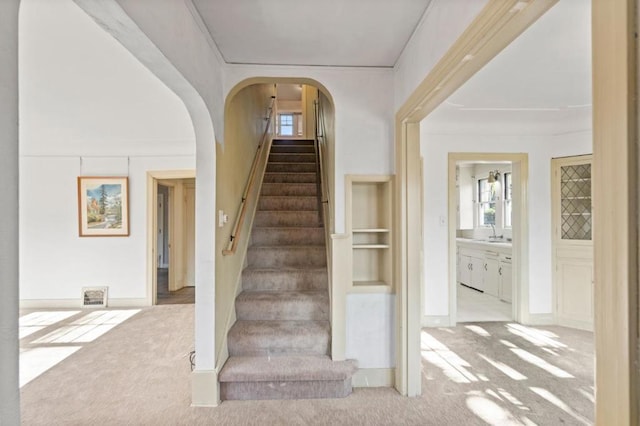 stairs with carpet and sink