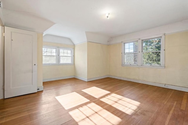 unfurnished room with wood-type flooring and vaulted ceiling