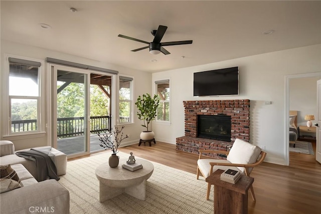 living room with hardwood / wood-style flooring, a fireplace, and ceiling fan